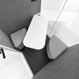 FocusPod Duo interior view showing two grey upholstered corner benches and the shaped white shared table.