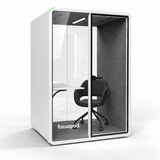 Angled view of FocusPod Solo Plus in Arctic White showing the glass front, side panel and optional ergonomic furniture.